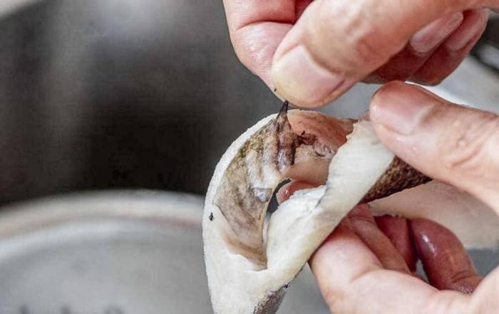 Cần loại bỏ lớp màng đen trong bụng cá để khử mùi tanh và chất độc hại